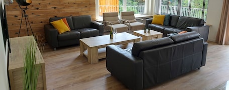 Wohnzimmer mit Smart-TV und Zugang zum Balkon und Küchen.