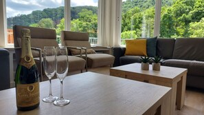 Wohnzimmer mit Smart-TV und Zugang zum Balkon und Küchen.