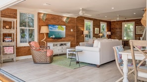 The living room has lots of comfy seating options in front of the TV...