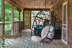 Comfy egg chair on back porch for relaxing or reading.