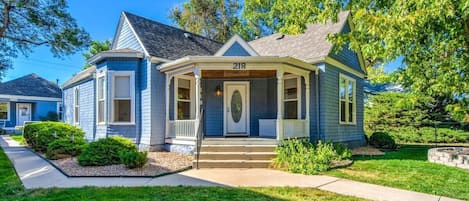 Welcome to Our Charming Guesthouse and Historic Home, Nestled in a Picturesque Setting with a Well-Manicured Yard and Inviting Sidewalk.