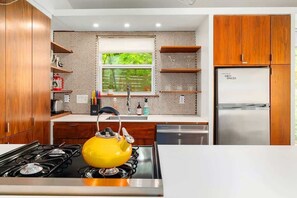 The kitchen is stocked with dishes and appliances to make meals at home.
