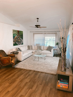 Living room 1. Equipped with a large 10x10 sectional, chair, TV and games.