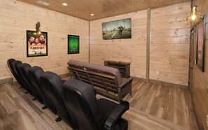Private Indoor Theater Room with Theater Chairs, a Futon, and a Big Screen TV
