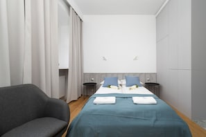 The elegant living area featuring a double bed and capacious wardrobe.