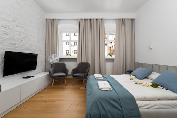 The living area features a double bed and a flat-screen television.
