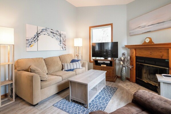 Cozy living room with sleeper sofa and fireplace.