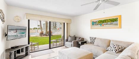 Spacious living room with comfortable couch and large TV - walks out onto patio