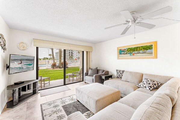 Spacious living room with comfortable couch and large TV - walks out onto patio