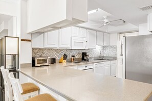 Modern kitchen with sleek white cabinets and stylish backsplash.