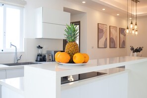 White and shiny kitchen perfectly fits the whole beautiful design of this apartment