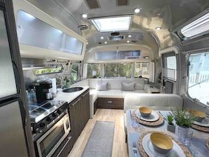 Camperini is equipped with all the appliances and comforts of a normal home - pictured here are the kitchen, sofa (pulls out to a small double) and the dinette (reconfigurable to a small bed).
