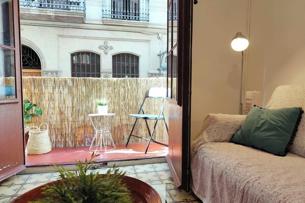 Step out onto the private balcony and enjoy the vibrant city views. The balcony features a small table and chair, perfect for enjoying a morning coffee or an evening drink. The balcony is enclosed with a bamboo screen, providing privacy and a touch of nat