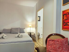 The bedroom features a comfortable queen-sized bed with crisp white linens and a bedside table with a lamp for a cozy and inviting atmosphere.
