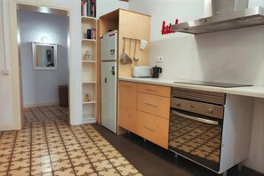 The kitchen features modern appliances, including a built-in oven and a stovetop, as well as a refrigerator and a toaster.