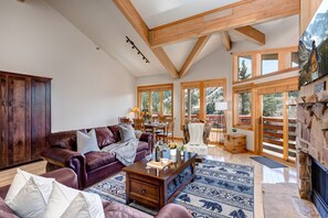 Living Room with plush leather furnishings, gas-assist fireplace, queen-sized Murphy Bed, vaulted ceilings, LG smart tv, and private deck access