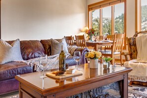 Living Room with plush leather furnishings, gas-assist fireplace, queen-sized Murphy Bed, vaulted ceilings, LG smart tv, and private deck access