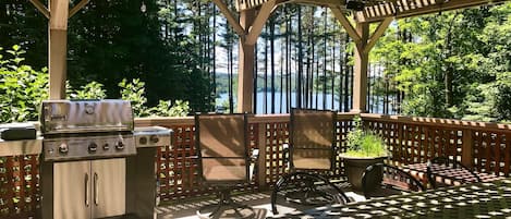 Second story deck with lake views, dining table for 8, sitting area and grill