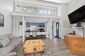 This view highlights the beautiful natural light in this home and how the open layout means you can kick back on the couch, dig into a meal or whip up a favorite recipe while staying connected to your loved ones.