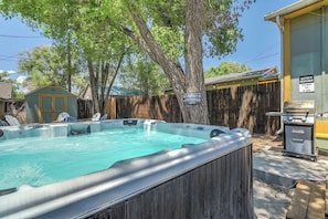Unwind in the spacious hot tub under the shade of trees, perfect for relaxing after a day of adventure. Enjoy the BBQ grill nearby for outdoor dining!