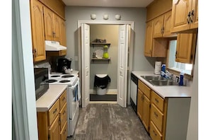 Fully Stocked Kitchen with pass through window and stackable washer and dryer. 