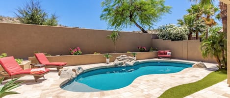 Stylish Travertine pool deck with turf