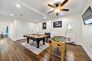 Game room includes full-size pool table, foosball table, and ROKU TV.