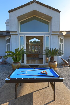 Indoor-outdoor pool table adjacent to living room. 