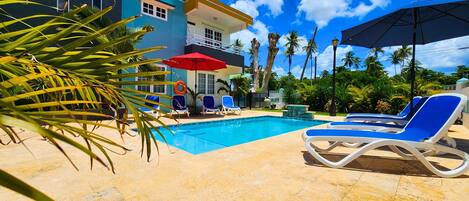 Pool area with lounge chairs and umbrellas.