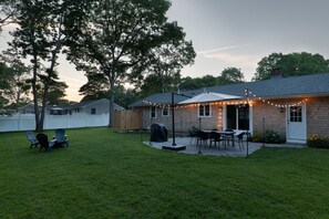 Large private yard with dining table, propane grill, umbrella and fire pit