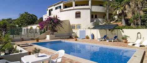 Large pool area with outdoor shower and sun loungers