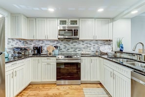 Fully Equipped Chef's Kitchen With Granite Countertops and Stainless Steel Appliances