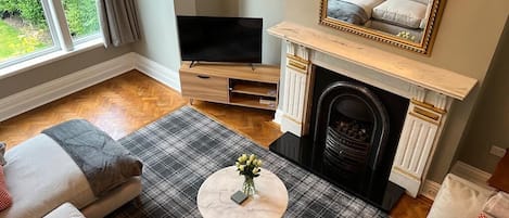 Living room with full wall of glass overlooking the garden and M&S furniture