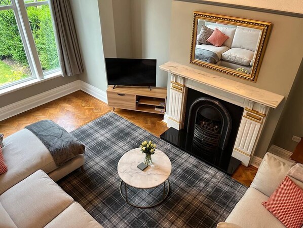 Living room with full wall of glass overlooking the garden and M&S furniture