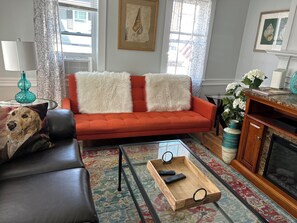 Orange sofa is convertible to allow sleeping on the first floor