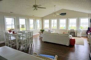 Living room with 2 large couches, large TV,  table seats 8. Panoramic water view