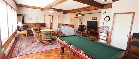 Large great room featuring slate pool table, card/game table, and 65" smart tv.