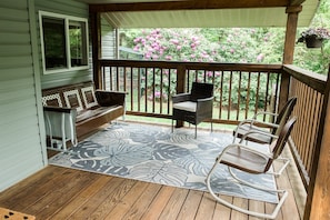 Large front porch with retro glider and rocking chairs plus extra wicker seating