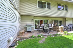 Outdoor patio with with dining table, gas fire pit, and grill