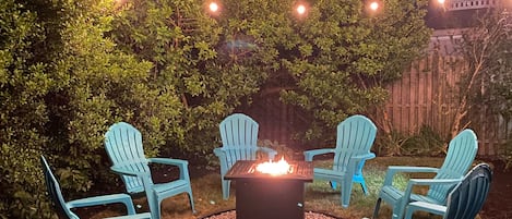 Gas fire pit with ample seating and string lights for the perfect evening hang