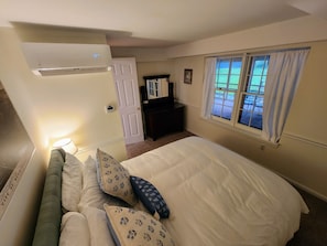 Bedroom has an in-room ac/heater and dresser with tilting mirror.