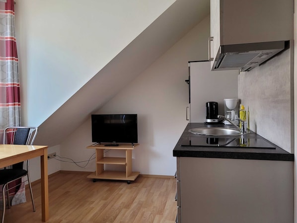 Wohnküche mit Couch und Esstisch (Dachschräge)