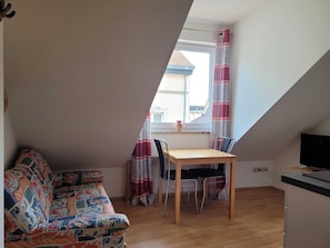 Wohnküche mit Couch und Esstisch (Dachschräge)