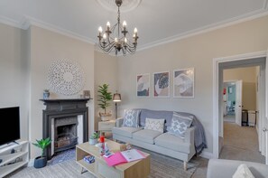 Living room that comes with a fireplace and a TV with Netflix access.