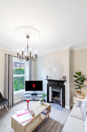 Living room that comes with a fireplace and a TV with Netflix access.