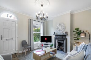 Open space living area with natural light that  comes with a fireplace and TV.