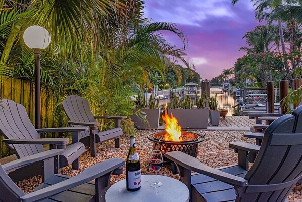 Waterside seating with firepit in the bottom of this tropical yard