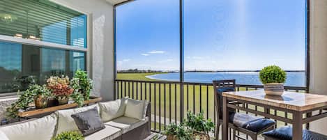 Screened in balcony area with view of lake and golf course 
