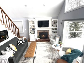 Main floor living room with gas fireplace and smart tv and incredible views