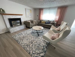 Living room with gas fireplace, sofa, smart tv and chairs